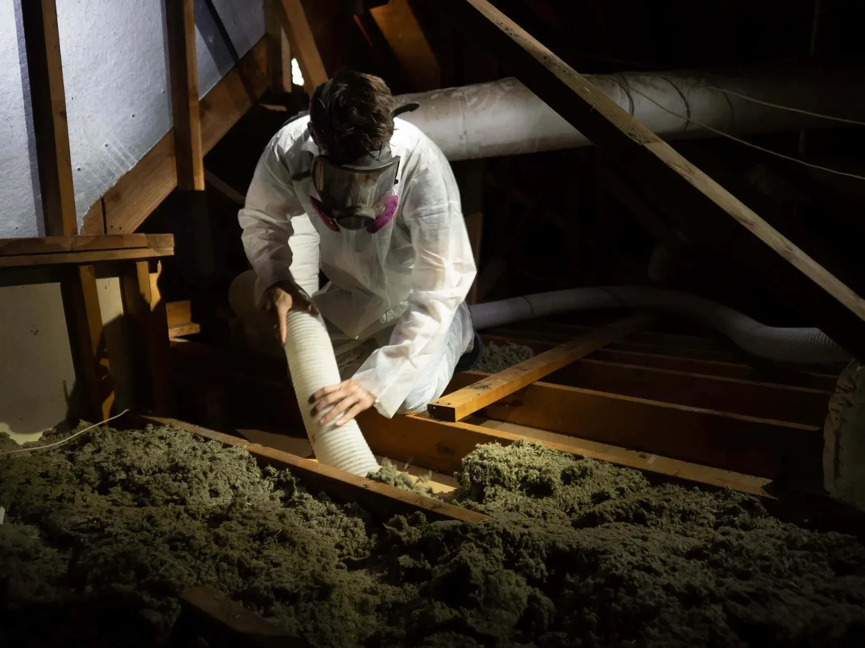 Old attic insulation being vacuum-removed by Superior Attic